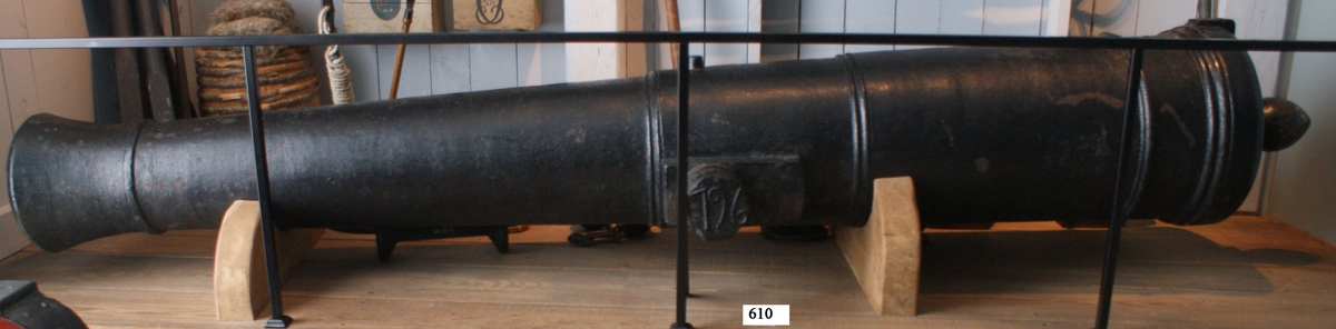 24-pundig slätborrad framladdningskanon av 261 kulors vikt, av gjutjärn. Kanonens gjut. nr 557. Vikt = 3380 kg. Märkt å ena tappen "ÅB" och å den andra "1796". Kanonen gjuten vid Åkers styckebruk år 1796. Har tillhört bestyckningen å Kungsholmsfort. Utl. till chefen för Bl. kustartilleriförsvar 8 maj 1962, ver. 143 (placerad på Drottningskär) ver 143 april 1979.
Diam = 420 till 600 mm