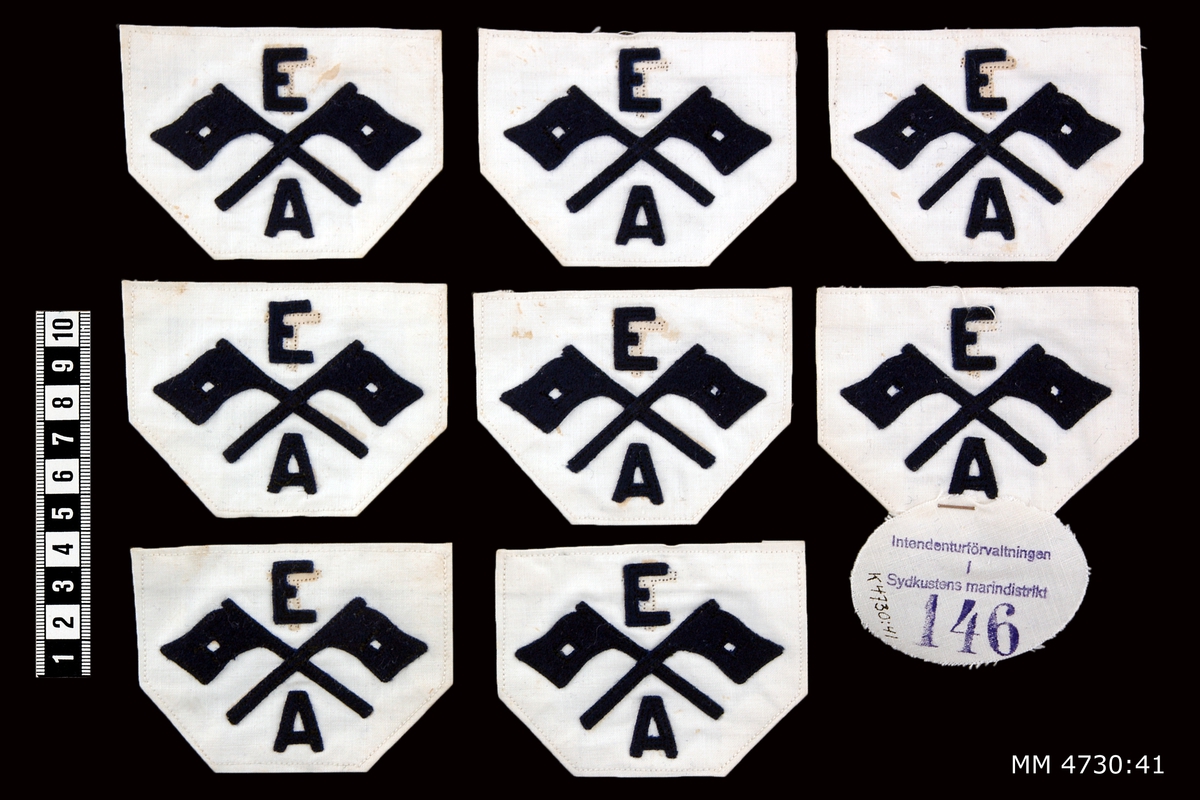 Yrkesbeteckning, signalflaggor med E och A, M/26. Av blått kläde på vit botten. För eldledningsman och avståndsobservatör. 9 stycken.