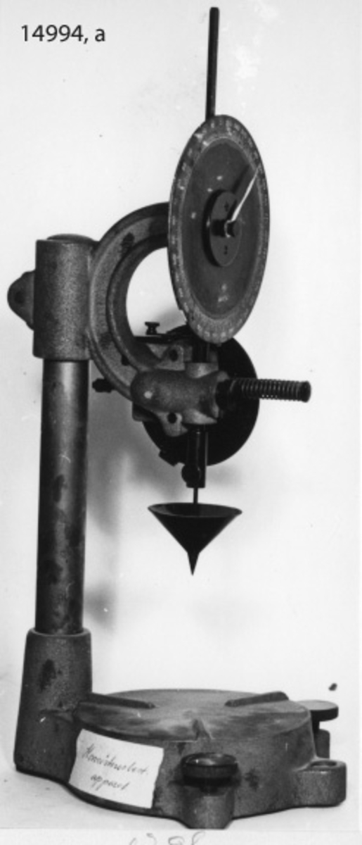 Apparatens olika delar sitter på ett bågformigt glidstycke, ställbart i höjd- och sidled på en rund stång, vars nedre del är fastsatt på en gjuten bottenplatta.