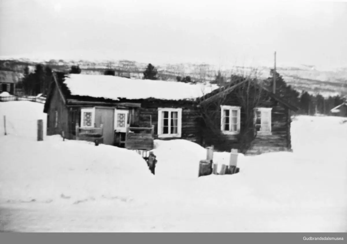 Huset på Bøverheim, det er vinter og snø, ca. 1960, trær og fjell i bakgrunnen.
