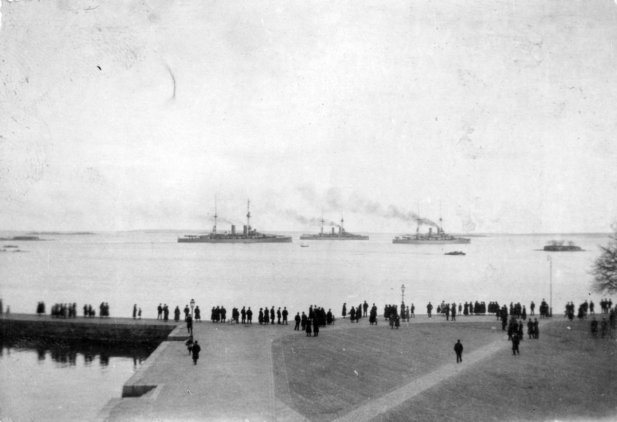 Folksamling bevittnar fartygen som går förbi utanför Karlskronas hamn.