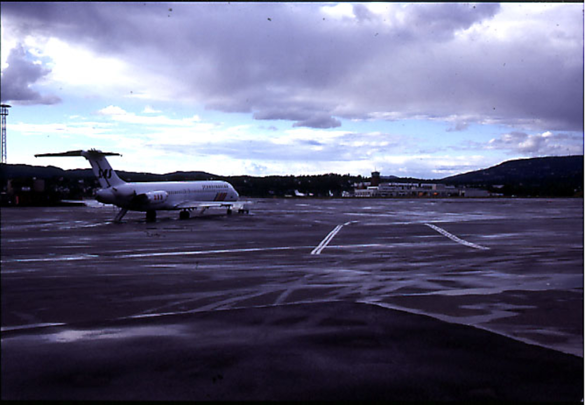 Lufthavn, 1 fly på bakken i forgrunnen (fra SAS). Terminalbygningen og kontrolltårnet bak.