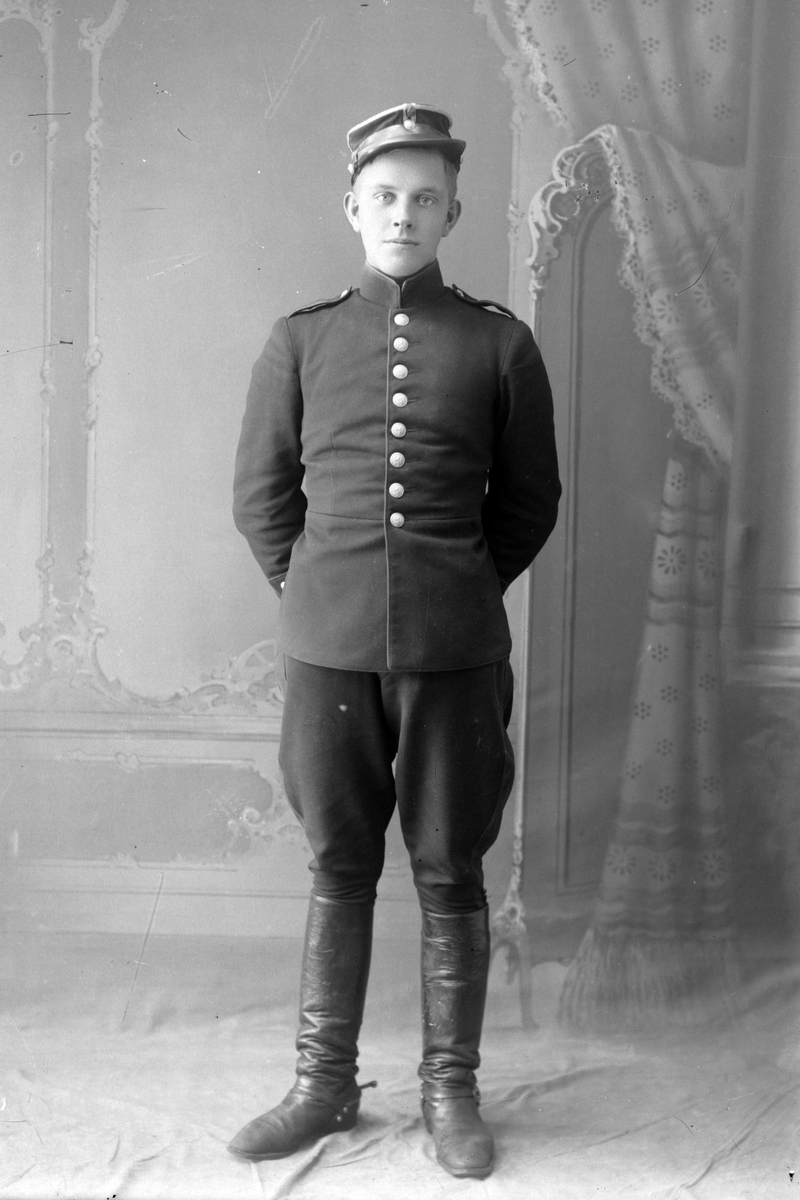 Studioportrett av ung mann i uniform.