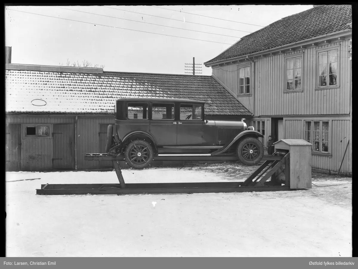 John Dahles bilverksted, bakgården til St. Marie gate 112 i Sarpsborg. Bil står på en smørebukk, ørn på panser, dekk merket Oakland, kjetting på bakhjul. Ukjent gutt.

 Bygningen til høyre er St. Mariegate 112. John Dahle hadde bilverksted her fra 1920 til 1932. Bygningen brant i 1935 og det ble satt opp nytt verksted. A/S Østlandsk Auto startet opp i de nye lokalene.(Kilde: St. Mariegate gjennom tidene).
