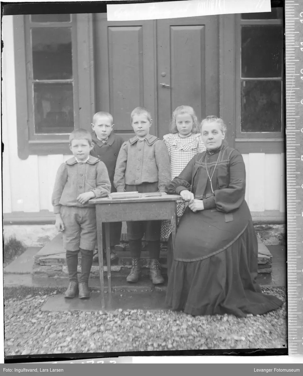 Gruppebilde av en kvinne og fire barn.
