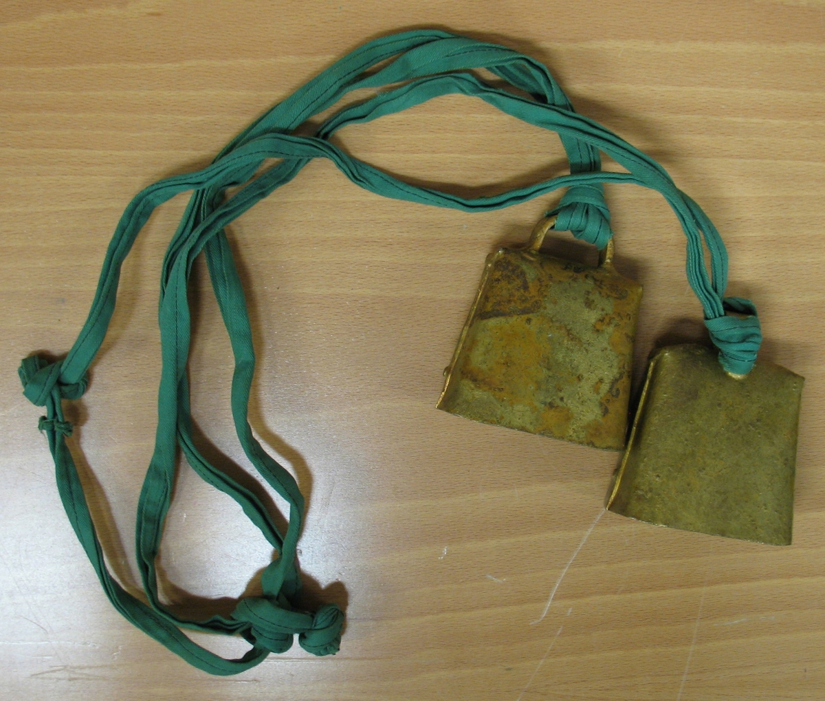 Två kobjällror som är sammansatta med ett grönt band. Användes i rytmikundervisningen på Vänerskolan. Det var även en träning när talet skulle utvecklas hos eleverna.