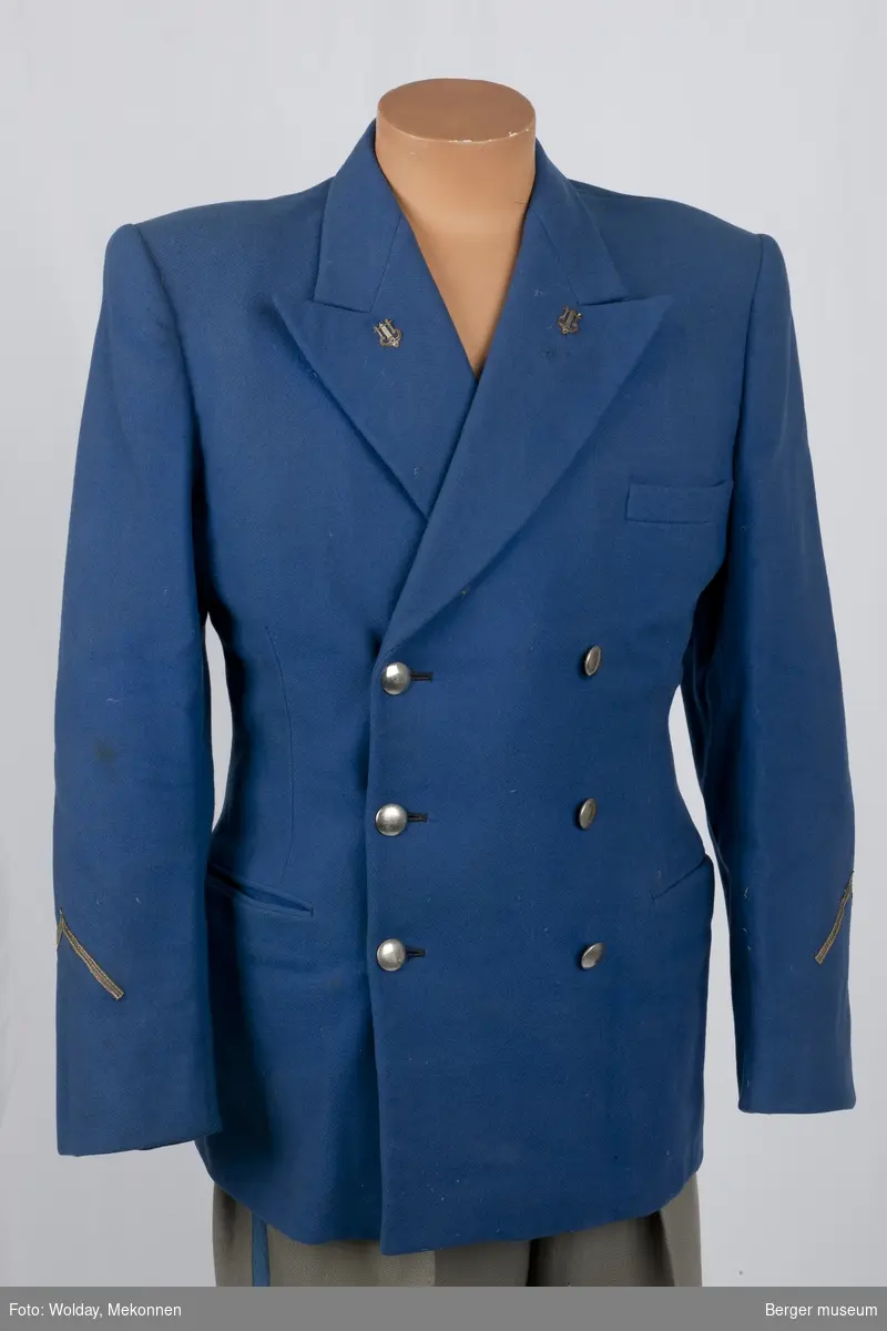 Dobbeltkneppet korpsuniformsjakke i kornblått stoff med silkefor i svart, og i beige i armene.