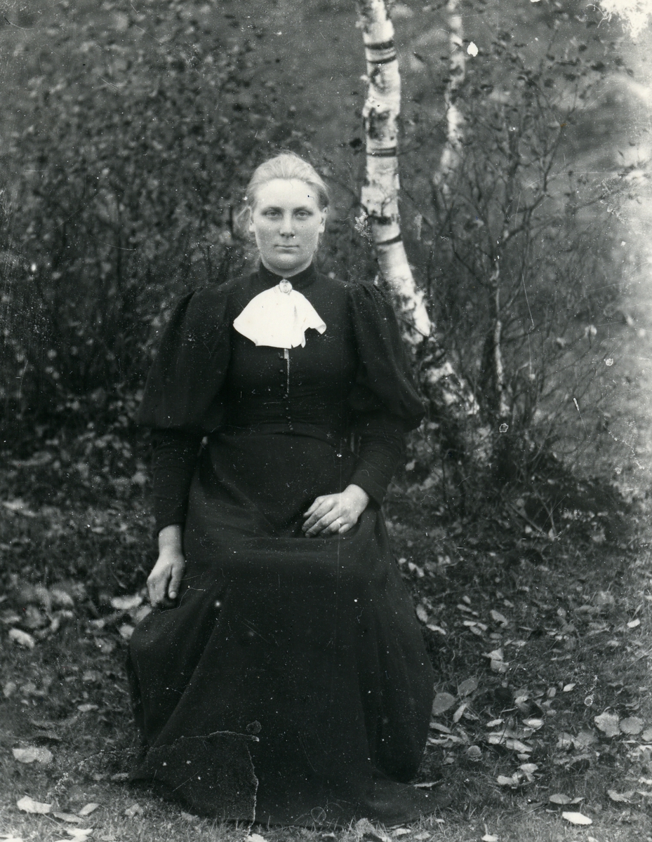 Kvinne fotografert med lerretbakgrunn, halvfigur