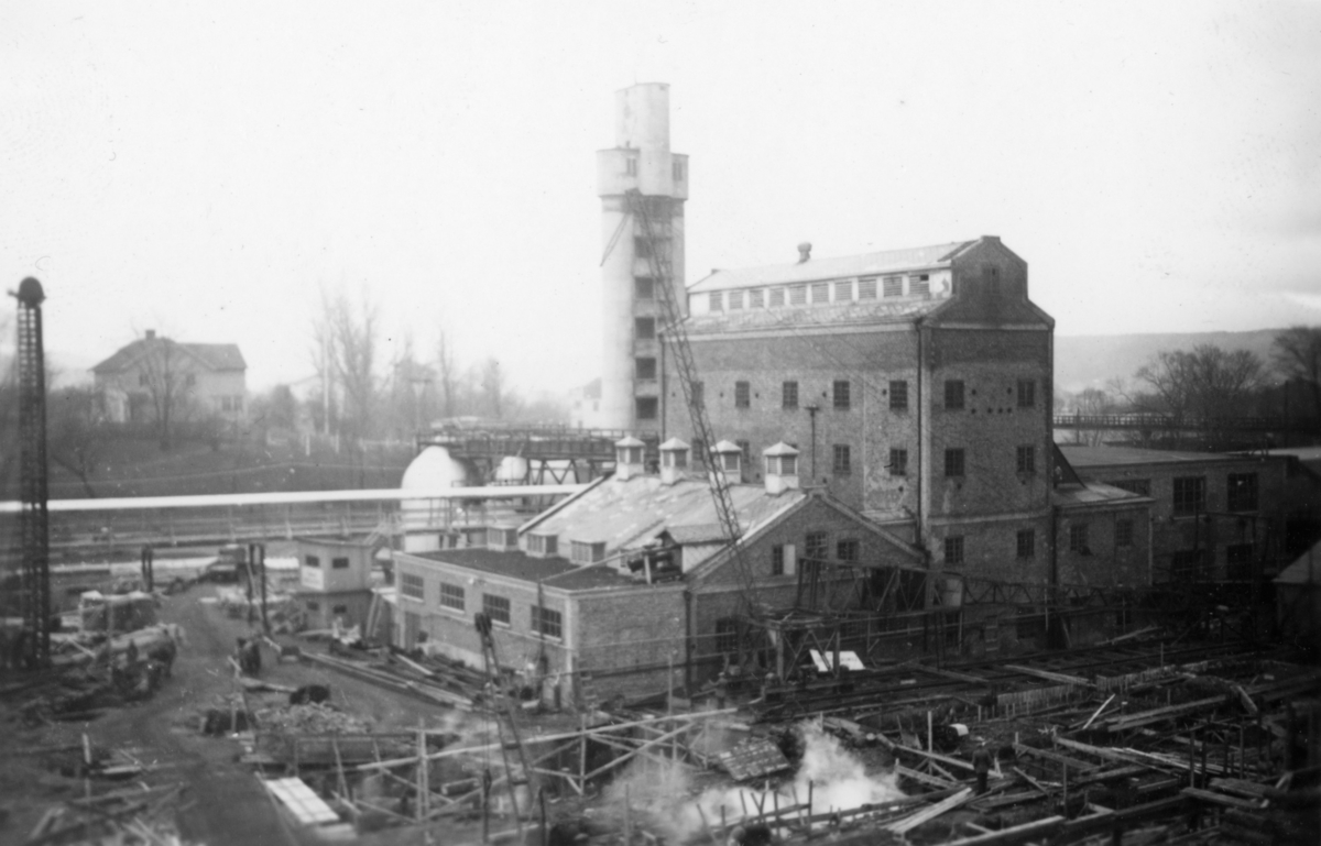 Rivning för uppbyggnad  av lagerbyggnaderna 110 och  111 på Papyrus fabriksområde, . I bakgrunden Privatvägen 6. 
10/12-1945.