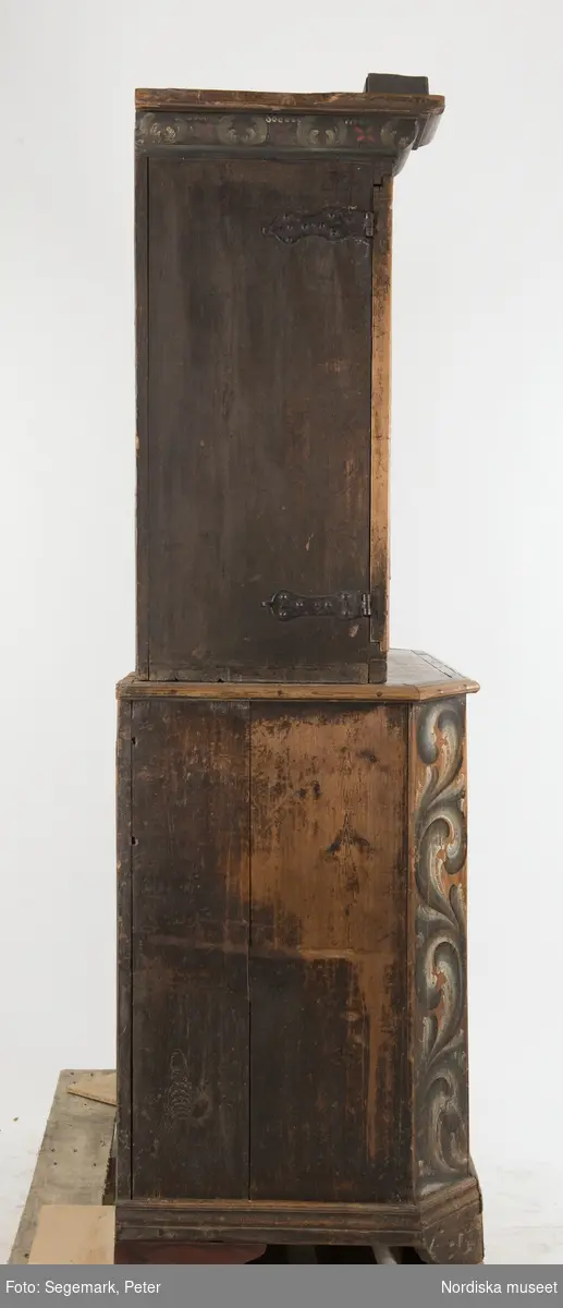 Katalogkort:
"Skänkskåp i två delar, den nedre m. en enkel dörr, den övre m. dubbeldörrar innanför dessa två hyllor samt skedhylla. Till dubbeldörrarna en nyckel. Märkt: 1783[i avbildande, snirklig skrift]"