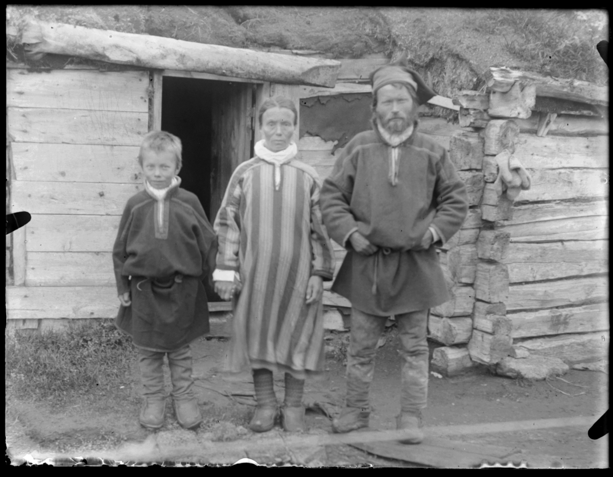 Samisk familie fotografert ved huset sitt