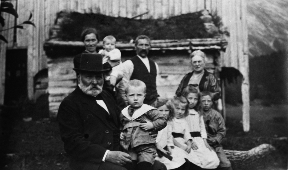 Gruppebilde av en familie sammen med Børre Berli foran et hus.