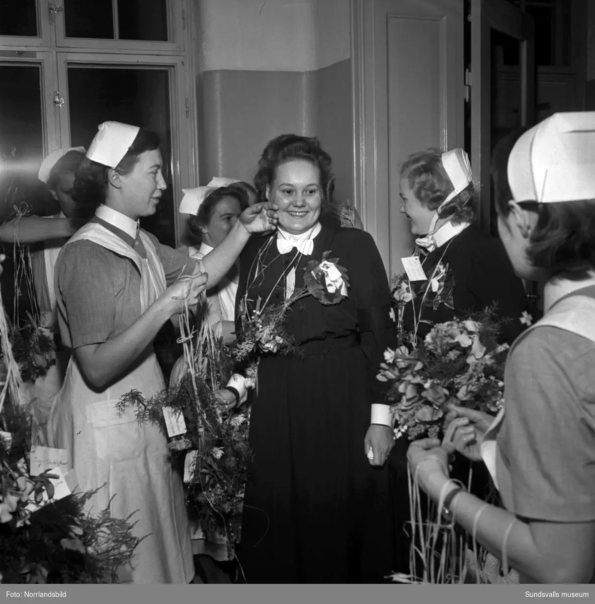 23 nya sjuksköterskor invigda vid lasarettet. På första bilden är det Ingegerd Söderberg, Essvik, som gratuleras av mamma Dora och pappa Konrad.