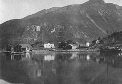 Ørnes gamle handelssted en jekt ligger på havna. Fjell bak. 