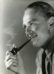Portrett av mann med pipe i munnen.