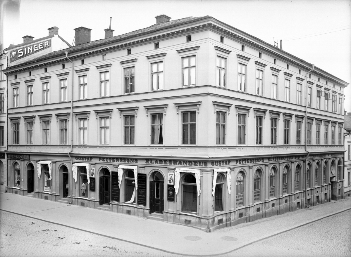 Gustaf Pettersson, klädeshandel.
Trevånings hyreshus, hörnhuset Drottninggatan - Nygatan.