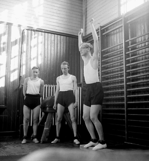 Interiör av gymnastiksalen, tre pojkar.
P.M.