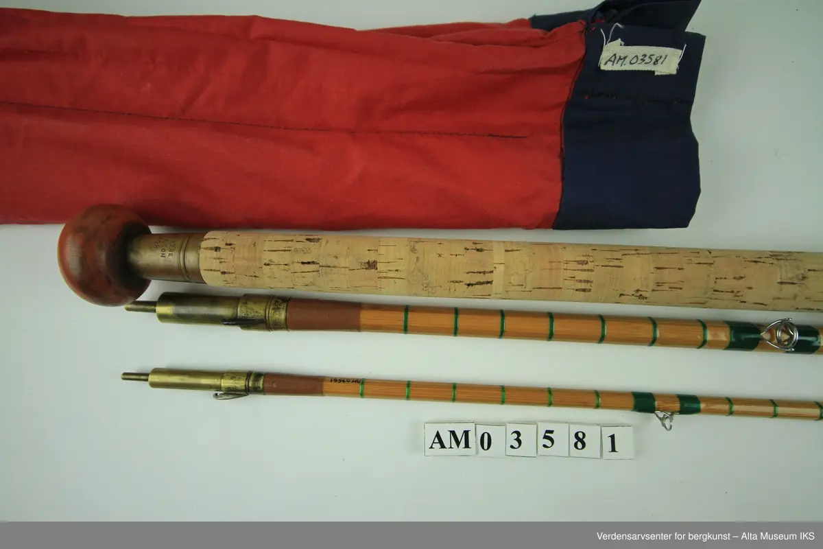 Tohånds fluestang. Tredelt. Tungbygd splitcane med stålkjerne. klasse # 11-12. Skruholker (kom etter knyteholkene) av messing. Sliding ring snellefeste. Har vært brukket i toppen mellom andre og tredje ring. Nye grønne surringer. Endebutt i messing og gummi.