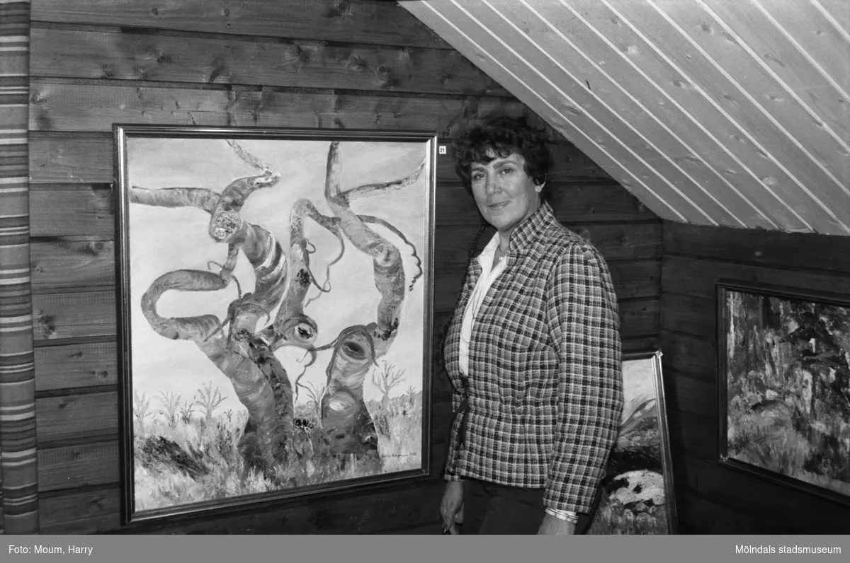Konstnären Gullan Rutgersson ställer ut sina tavlor i Lindome, år 1983. "Tittar man närmare på Gullan Rutgerssons "Fikonträd i vila" upptäcker man människor, fåglar och andra fantastiska figurer."

För mer information om bilden se under tilläggsinformation.