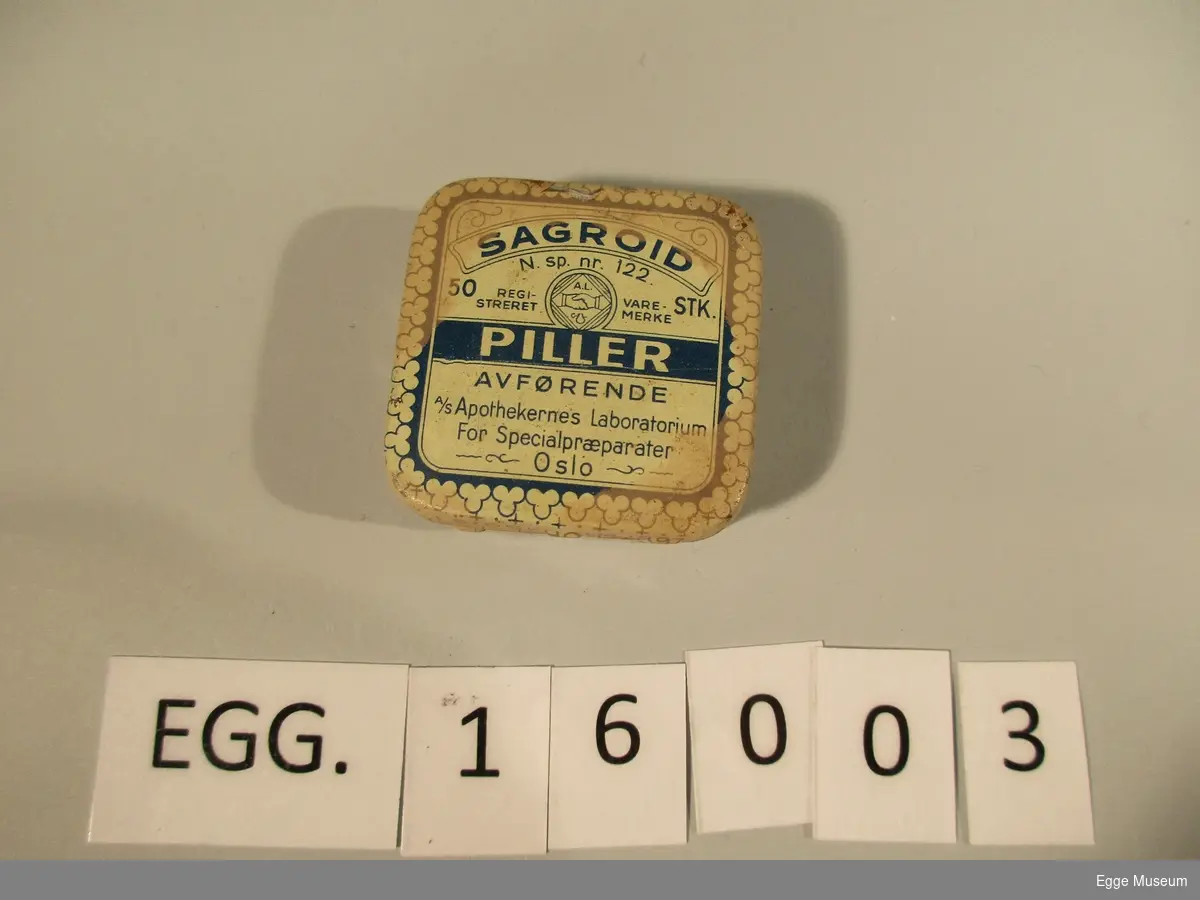 En liten pilleeske med piller. På fremsiden står det skrevet "Sagroid piller, avførende. A/S Apothekernes Laboratorium For Specialpræparater, OSLO. 50 stk. Registrert varemerket."

På baksiden av esken står det følgende: "hver pille inneholder extr-rhamni purshianae sicc.0,2g saccharo obducto

1908