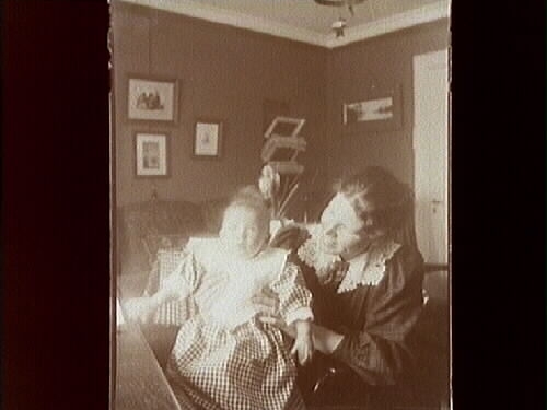 Rumsinteriör, en kvinna och ett barn.
Gerda Thermaenius med dottern Maj.