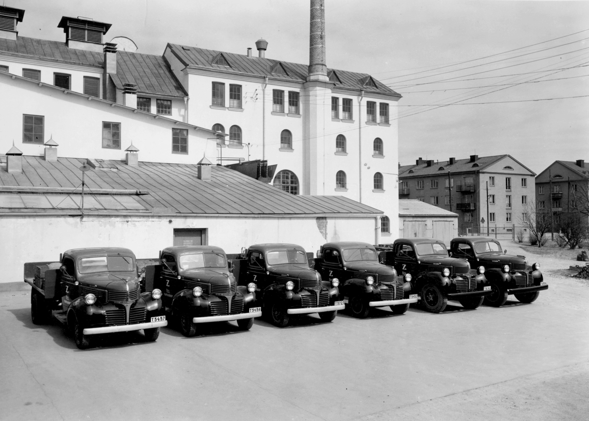 Zenks Bryggeris nya bilpark, ca 1945-1946. Bilarna inköptes genom Motorkompaniet i Örebro och var av märket Fargo.
Byggnaderna på bilden: till höger utanför grinden syns hyreshuset Vivallagatan 18. Innanför grinden syns "plåtskjulet" som innehöll skräp och ved. Den höga fabriksbyggnaden är bryggeriet med i översta våningen lagervind och maltkross, 3:e våningen innehöll jästkällare, 2:a våningen laboratorium.
Den vita byggnaden med snedtak omedelbart bakom bilarna innehöll maskinhallen och i byggnaden bakom pumpades ölet upp på "skeppet" för avsvalning.
Den lilla envåningsbyggnaden framför skorstenen var lagerbyggnad för färdigvaror med butik i kortändan.
Zenks bryggeri såldes 1950 till Norlings bryggeri, liksom Örebro bryggeri.