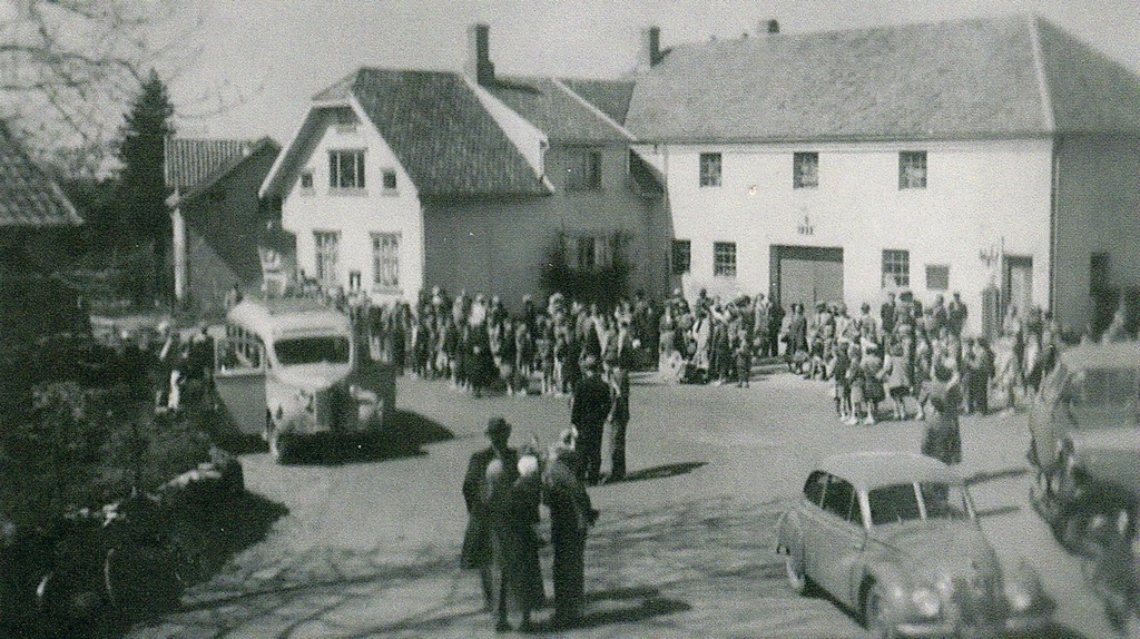 17. mai på Undheim tidleg på 1950 talet. Samling framfor det gamle Handelslaget for å stilla opp til å gå i tog ned til skulen på Tunheim. Bussen tilhøyrer Karl Sikveland.