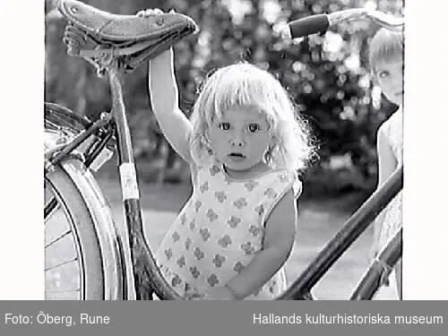 Flickorna (kusinerna) Ingmarie (i förgrunden) och Åsa vid farmors cykel.