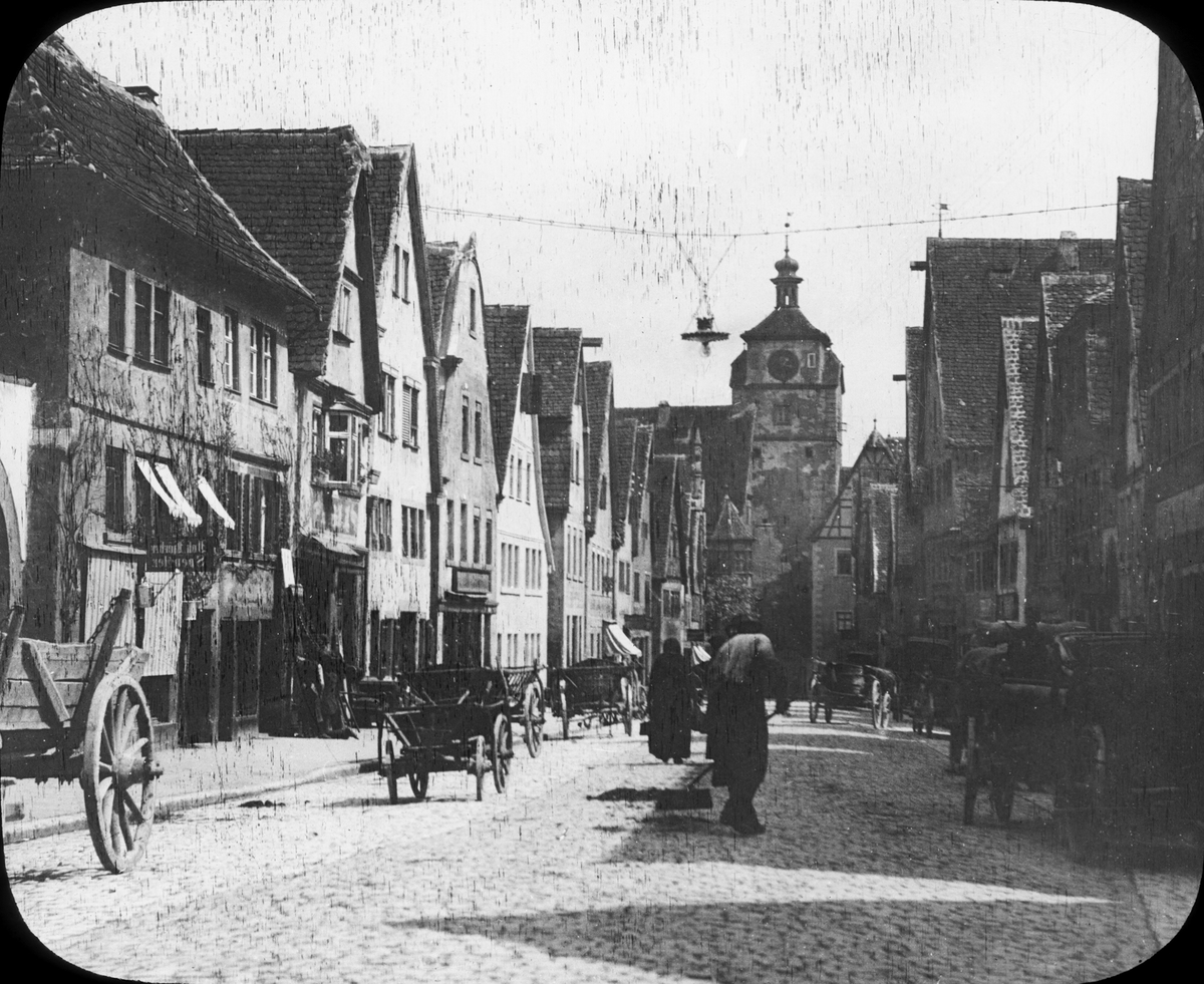 Skioptikonbild med motiv från gata i Rothenburg.
Bilden har förvarats i kartong märkt: Rothenburg III. 1901. 9. Text på bild: "Würghurger Strafse", troligen avses Würzburger Strasse.