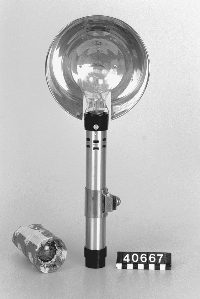 Blixtaggregat av plast metall och glas med blixtlampa i reserv.
Tillbehör: Blixtlampa i reserv.