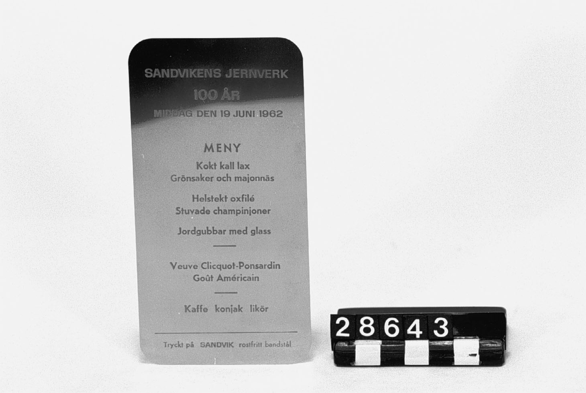 Menu, tryckt i guld på Sandvik rostfritt bandstål, 0.11 mm tjockt, för deltagarna i Sandvikens Jernverks 100 års jubileumsmiddag 19 juni 1962.