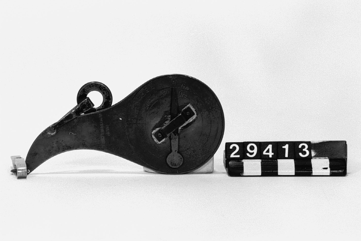 Brevvåg för 0-250 gr och portosatserna angivna i ören, 10-30 ören, av mässing. Vågen hålles med två fingrar sedan brevet fastsatts med en klämma. Märke: Frans Svanströms Patent.