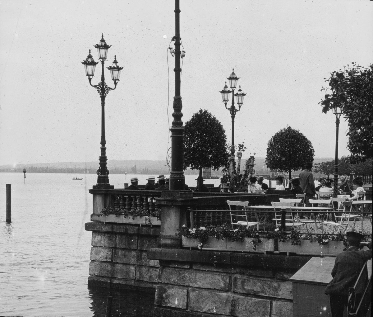 Skioptikonbild med motiv från Konstanz. Uteservering vid Bodensjön.
Bilden har förvarats i kartong märkt: Resan 1906. Arlberg- banan 2. Konstanz 6.