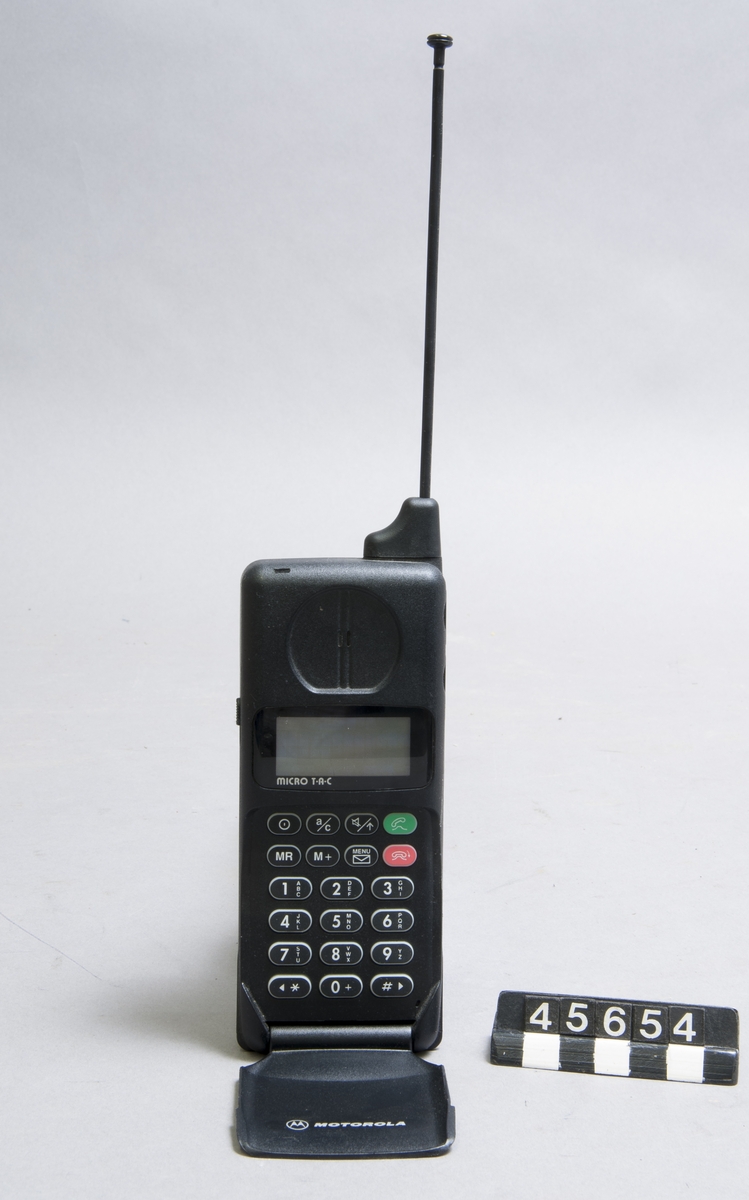 Motorola GSM mobiltelefon samt SIM-kort för GSM mobiltelefon IMEI: 442742405790300 Mobilnummer: 070-787 15 37  Laddare IntelliCharge XT/SLN9347B ser nr 1624H1624T  med nätaggregat SPN4038A för 220V/50Hz - 12V= Batteri Motorola 6V nickel-kadmium märkt: SNN4102C IUYI.4P-EEI Laddare för cigarrettändaruttag märkt "Motorola 5200/7200"  Simkort Comviq GSM märkt "Det intelligenta telekortet" samt: "Upphittat kort skickas till: COMVIQ Kundtjänst, Box 429, 691 27 Karlskoga. Telefon 020-222040.".
Tillbehör: Laddare med nätaggregat, laddare för cigarettändaruttag, SIM-kort, batteri.