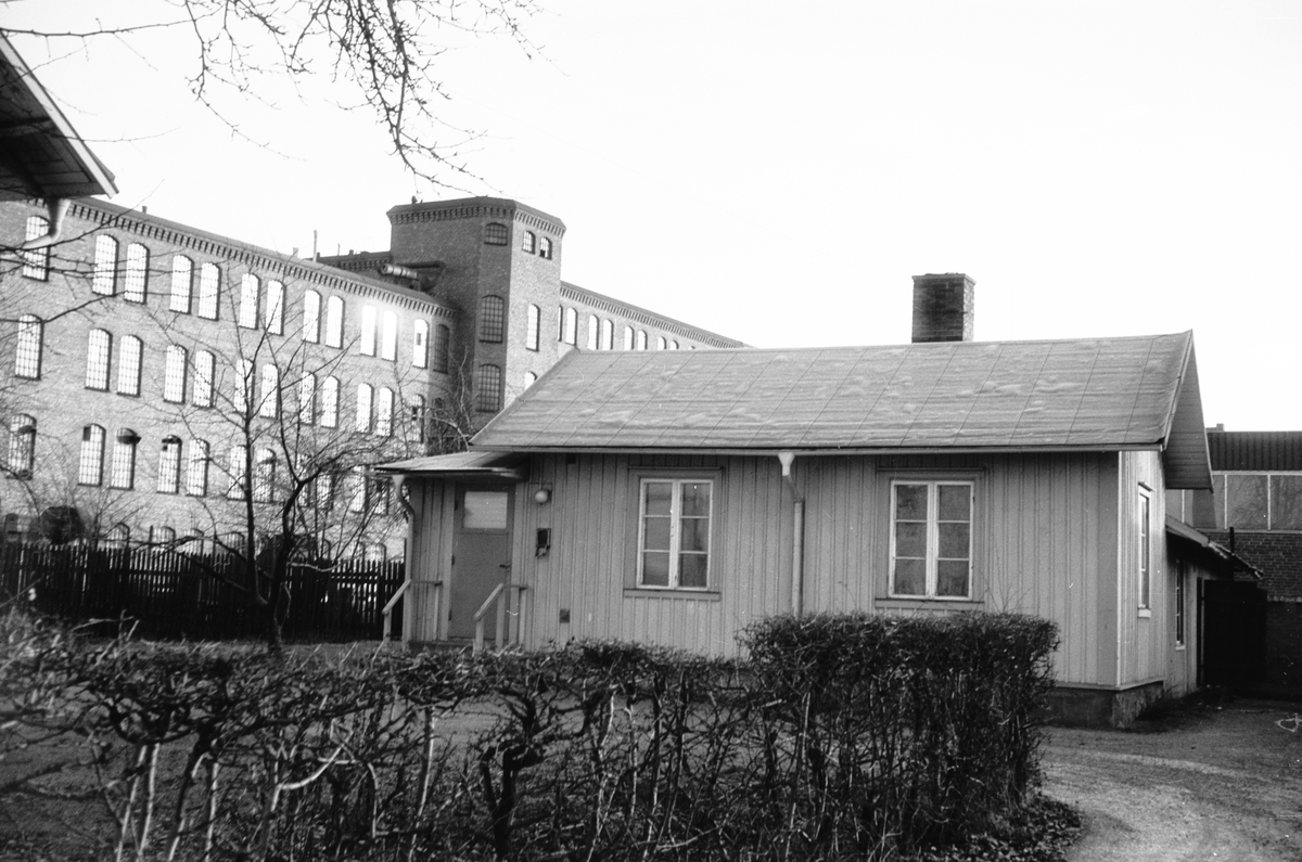 Ett litet trähus i Huskvarna, med Husqvarna AB till vänster..