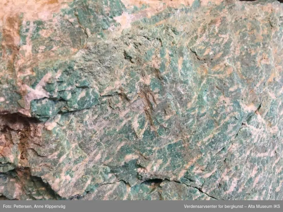En stor stein. Veier mye. Grønnfargen kommer av små mengder bly (Pb) eller vann i mikroklin strukturen. Anvendes av og til som smykkesten. I Norge særlig kjent fra Evje, Tørdal og Sørfold. Den opptrer i pegmatittganger som er dannet ved relativt lav temperatur. Større forekomster er kjent fra USA, Ural, Madagaskar, Namibia og India.