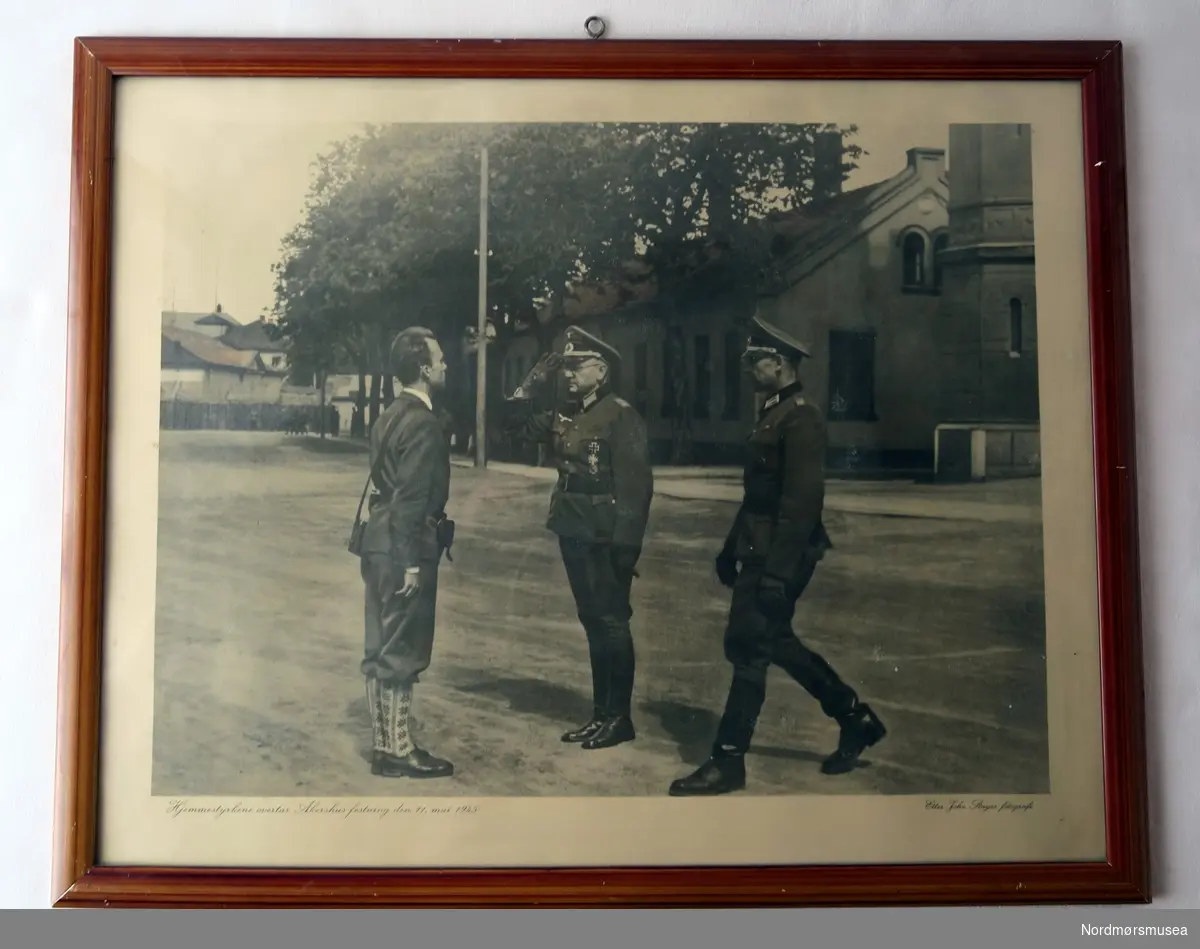 Bildet viser to tyske offiserer som overgir Akershus festning til et medlem fra Heimestyrkene.