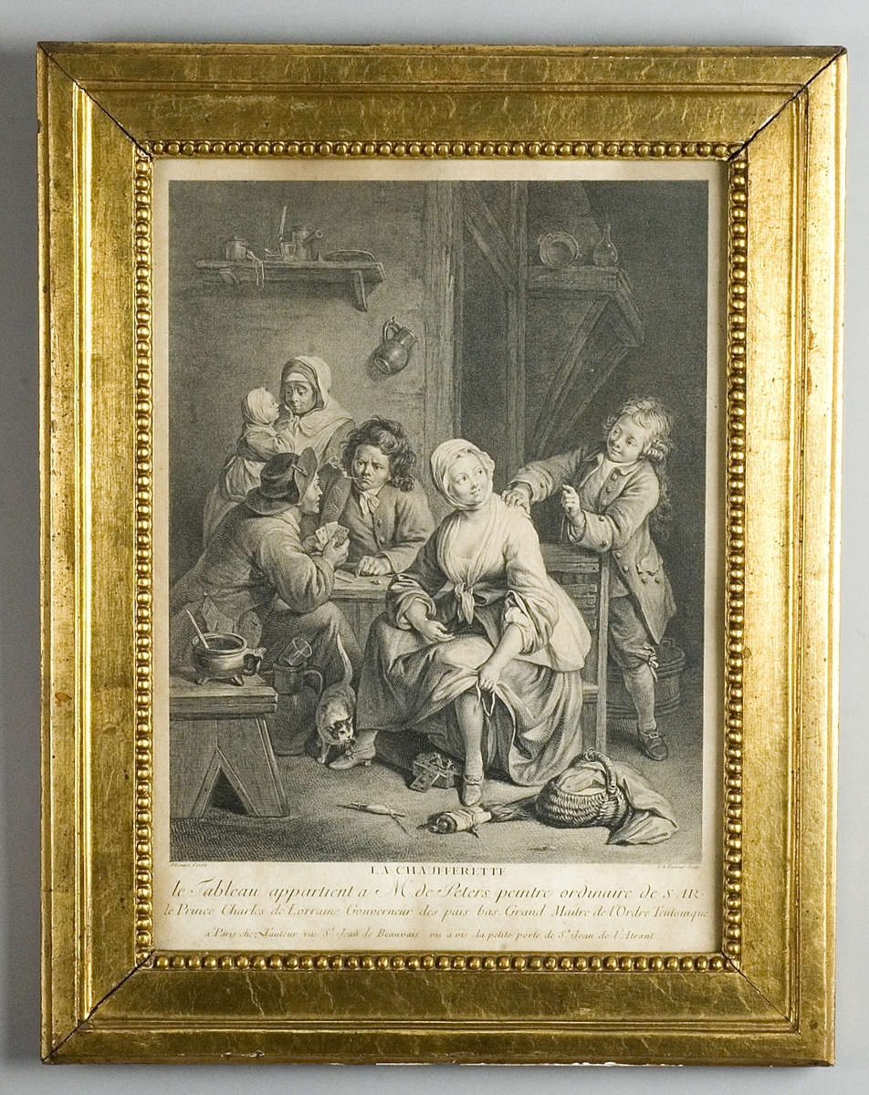 Interiör med en sittande kvinna som värmer sig vid en glödpanna, två kortspelande herrar, en ung man samt i bakgrunden en kvinna och ett barn samt en katt.