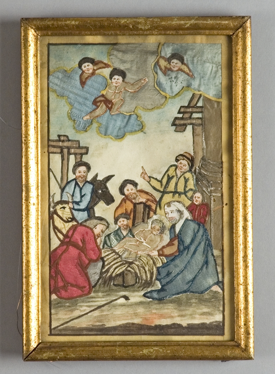 Jesusbarnet i krubban omgivet av Josef, Maria och herdarna samt en åsna och en oxe. Ovanför tre änglar på moln, t.v en pelare, på marken ligger en stav. Motivet omges av en målad ram.