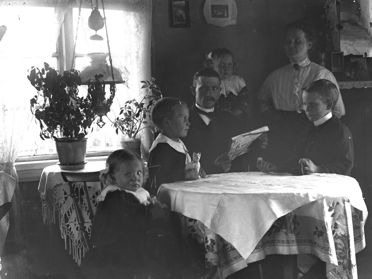 Familjen Ada och Klas Toresson, Hägna i Karl Gustav, med barnen (från höger) Vilmar, Artur, Elsa och Signe. Familjen är fotograferad inomhus, sittande vid ett bord.