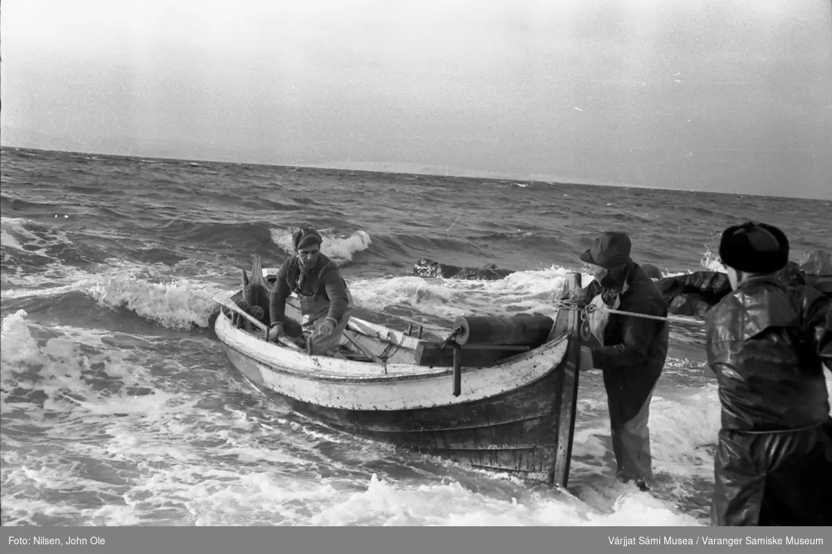 Brødrene Andersen fra Gurluovttgohppi / Godluktbukt har kommet trygt på land etter fisketuren. En tredjemann står og hjelper til. 28. februar 1967.