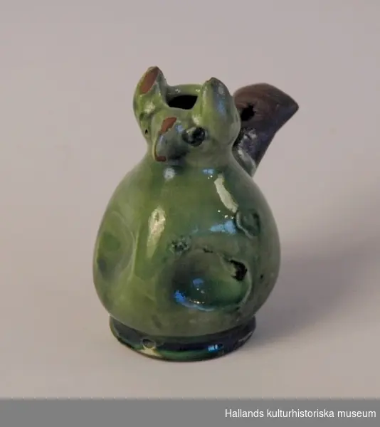 Lergök i form av en uggla. Vattenflöjt. Av keramik, med blyglasyr, grön. 