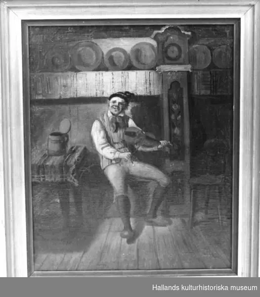 Oljemålning föreställande August Bondesson spelande fiol i en ryggåsstuga. Guldfärgad träram. Av ritmästare Carl Gustaf  Holmgren.