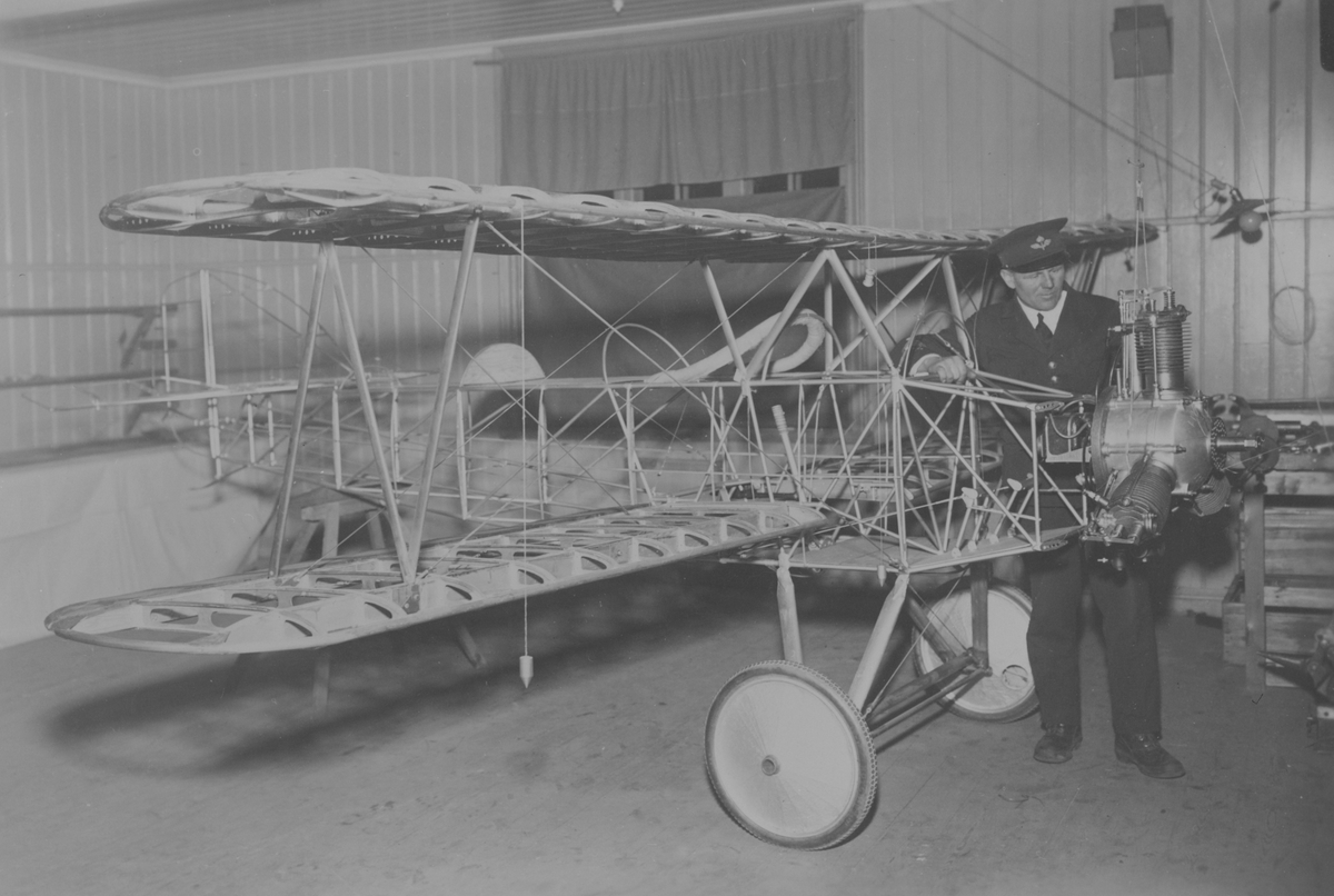 Flygplansbygge. Stommen till civilflygplanet Holmberg Racer har satts ihop i en verkstad. Flygplanstillverkaren George Holmberg står vid ena flygplansvingen.