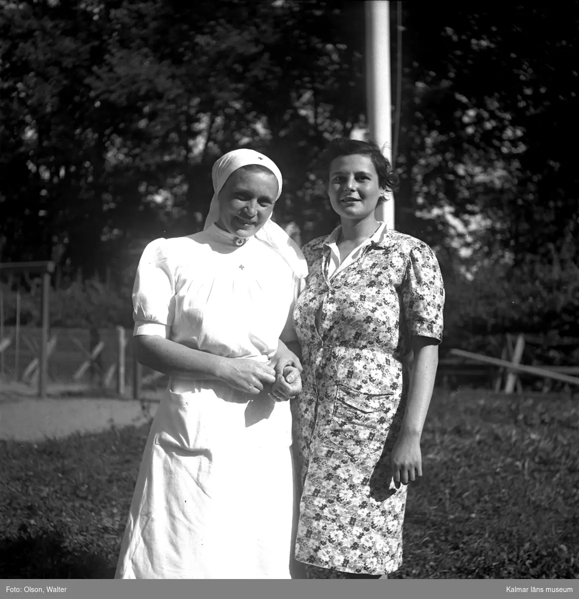Patient och sköterska på Beredskapssjukhuset vid flaggstången.