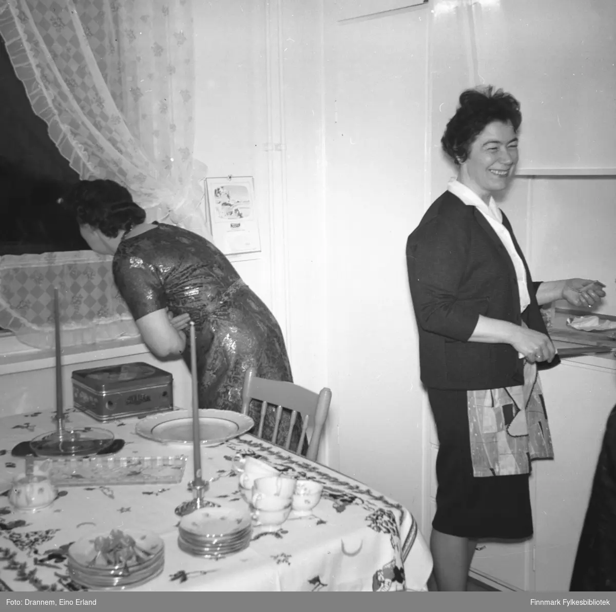 To damer på kjøkkenet til familien Drannem i Hammerfest. Hun til venstre på bildet er ukjent, til høyre står Jenny Drannem.