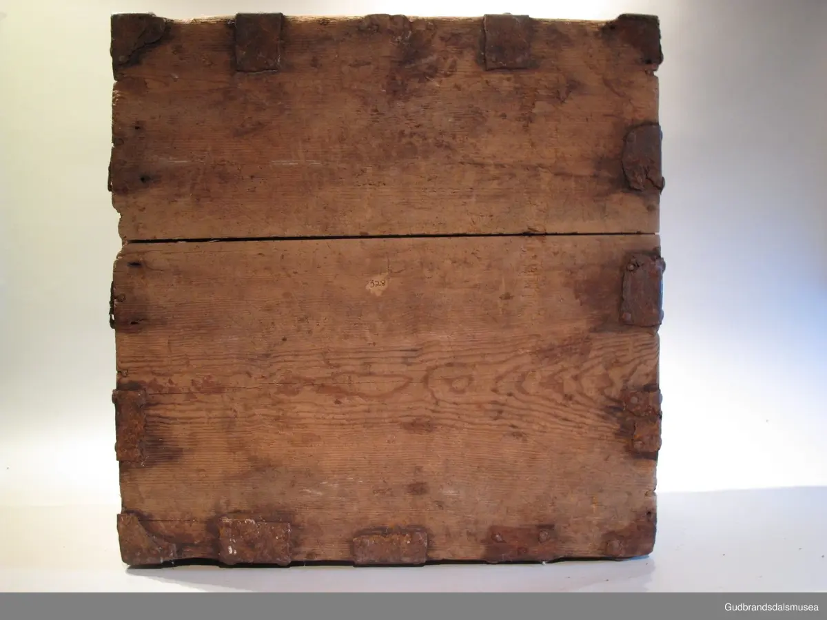 "Ferdaskrin. Umalt. Over heile skrinet går det beslag med innhogga stjerner og hjerter. Fra Østre Gausdal. Merknad 2, også kalla Føringsskrin" (Jf. Katalog for Lom Bygdesamling, 1925).
Skrinet har 1 rom. LOKK: satt sammen av 3 bord, holdt sammen av sidelister på innsiden og jernbeslag langs sidekanter på oversiden. Hengslet med 2 hengselbeslag på innsiden og  2 på utsiden av bakstykke.  1 stk. låsbeslag på innsiden av lokk.
SKRINSIDER: gjæra sammen, holdt sammen av hjørnekantbeslag utvendig; profilerte toppkanter.
BUNN: satt sammen av 2 bord, festet til skrinrammen med trenagler. Er i tillegg opprinnelig holdt på plass av 10 beslag festet til skrinbunn og sidestykker. Jernhandtak på hver side.
BESLAG: 5 jernbeslag i lengderetning på lokk. Tilsvarende 3 beslag og 2 hjørnebeslag på front og sider. Alle beslag er festet med jernnagler.
DEKOR. Ingen skurd- eller malingdekor. Skrinet har i stedet jernbeslag med utskårne hjerte- og stjerneformer som dekor. Muligvis fra 1600-tallet der treskurden ikke var fremherskende. Liknende dekor ses på LBY0319.
BRUK. Før kofferten kom i bruk hadde man reiseskrinet, som ble brukt til oppbevaring av bl.a. klær, verdisaker og mat på reiser. Skrinet hadde ofte et eller to mindre, smale rom langs den ene skrinsiden og ett større rom. De fleste reiseskrin var i tillegg forsterket med jernbeslag langs alle kanter og med en solid nøkkelhullås til sikring mot støt, slag og tyveri.