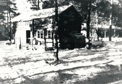 Eit tømmerhus i skogen.