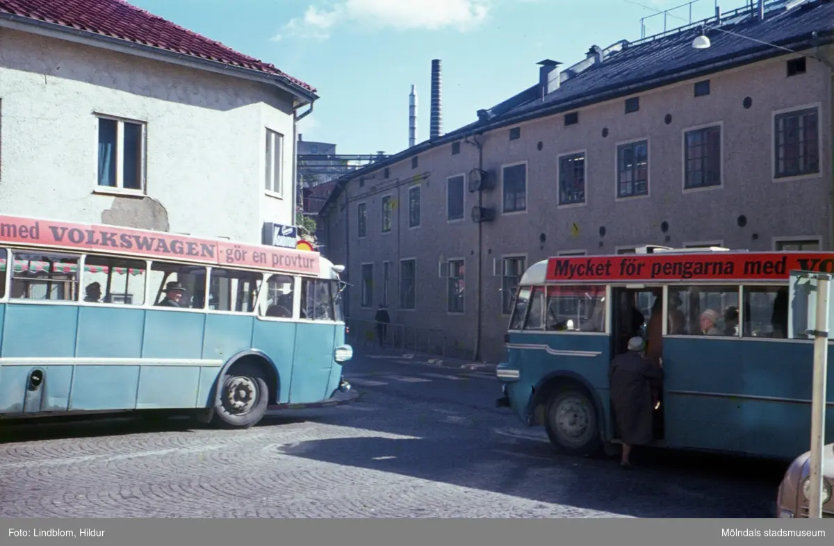 Två blå bussar står på Gamla Torget i Mölndal, 1960-tal. I bakgrunden till vänster ses huset Kvarnbygatan 45 och till höger Kvarnbygatan 6, byggnad tillhörande SOAB.

För mer information om bilden se under tilläggsinformation.