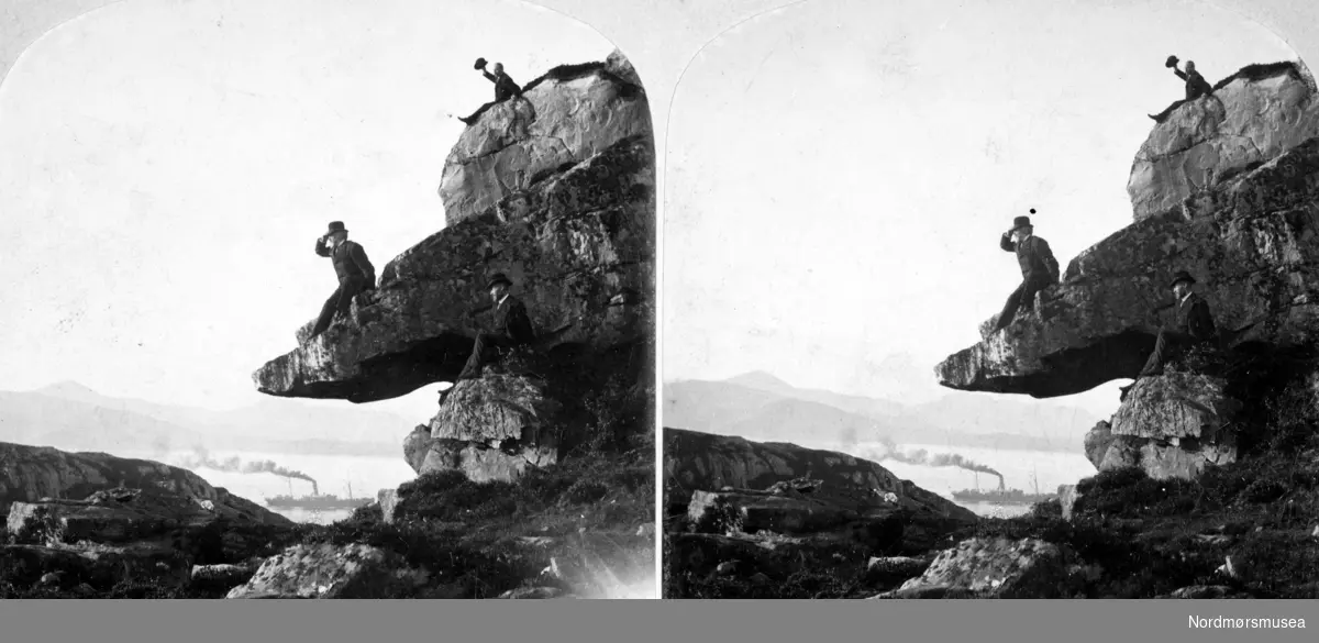 Et stereobilde, hvor vi ser tre menn iført dress og flosshatt på kanten av en fjellhammer ved Svartholsbukta. Bildet er trolig fra perioden 1902-1910. Et dampskip i bakgrunnen. Fra Nordmøre Museums fotosamlinger.